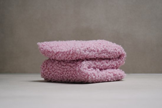 Roze teddy stof, dubbel gevouwen, met een zachte, krullende textuur.