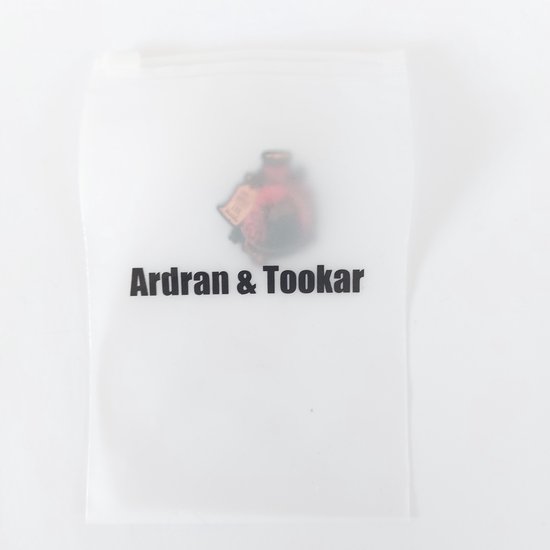 Een doorschijnend plastic zakje van Ardran & Tookar met een glimp van een pin.