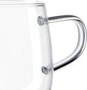 Close-up van de zilverkleurige, gebogen handgreep van een dubbelwandige glazen mok.