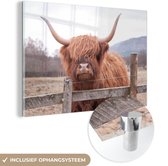 MuchoWow® Glasschilderij 180x120 cm - Schilderij acrylglas - Schotse Hooglander - Gras - Hek - Foto op glas - Schilderijen