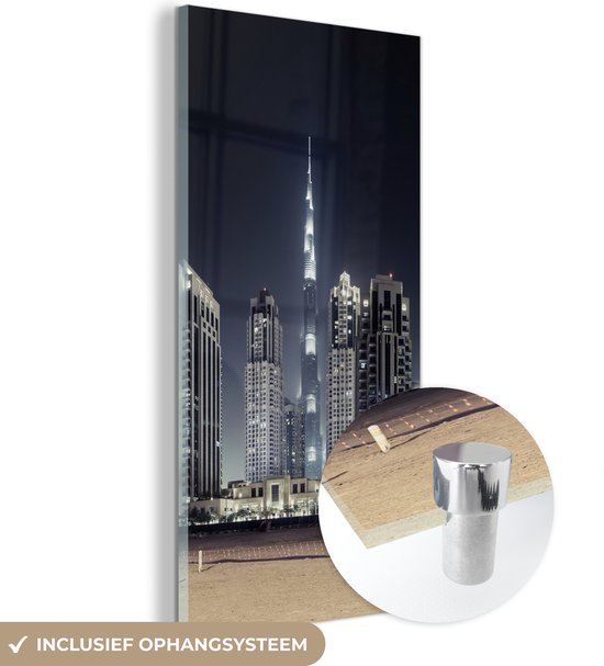 MuchoWow® Glasschilderij 40x80 cm - Schilderij acrylglas - De Burj Khalifa verlicht met andere wolkenkrabbers de lucht boven Dubai - Foto op glas - Schilderijen