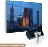 MuchoWow® Glasschilderij 120x80 cm - Schilderij acrylglas - Den Haag - Wolkenkrabber - Nacht - Foto op glas - Schilderijen