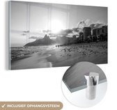 MuchoWow® Glasschilderij 160x80 cm - Schilderij acrylglas - De zon hangt net boven de bergen bij het Zuid-Amerikaanse strand Ipanema - zwart wit - Foto op glas - Schilderijen