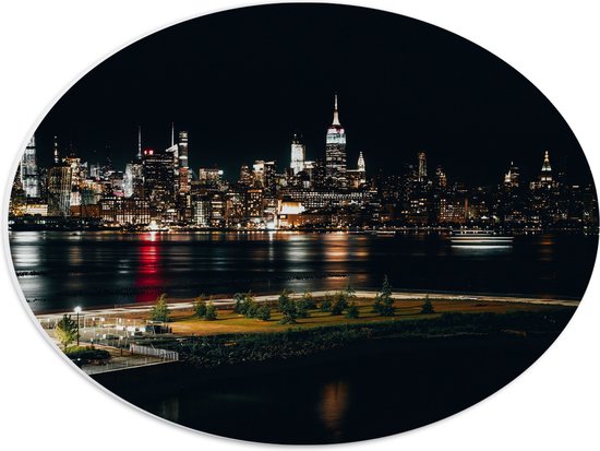 PVC Schuimplaat Ovaal - Skyline in New York in de Nacht - 40x30 cm Foto op Ovaal (Met Ophangsysteem)