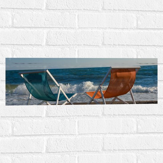 Muursticker - Blauw en Oranje Kuipstoeltje op het Strand aan de Kust - 60x20 cm Foto op Muursticker