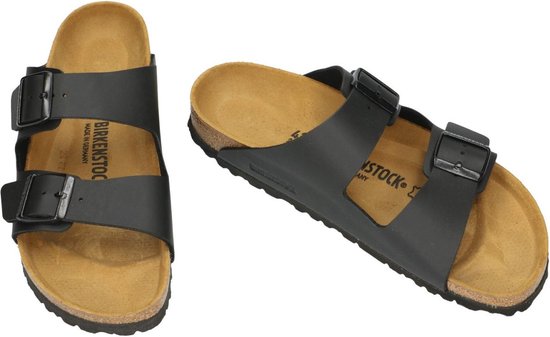 Twee zwarte Birkenstock Arizona slippers met kurken zool en gespen.
