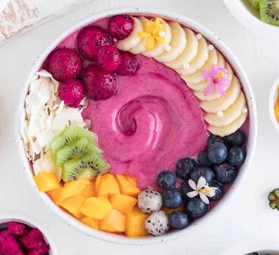 Acai bowl met roze pitaja, blauwe bessen, kiwi, mango, banaan en kokos.