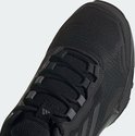 Close-up van de neus van een zwarte lage wandelschoen met veters en het Adidas-logo.