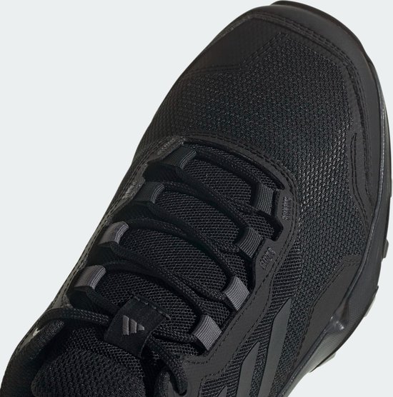 Close-up van de neus van een zwarte lage wandelschoen met veters en het Adidas-logo.