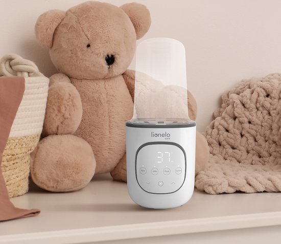 Witte Lionelo flesverwarmer met display op een plank naast een teddybeer en een mandje.