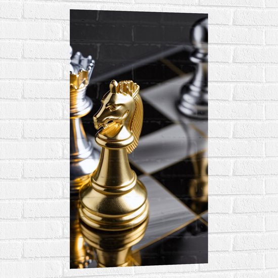 Muursticker - Foto van Drie Gouden en Zilveren Schaakstukken op Schaakbord - 50x100 cm Foto op Muursticker