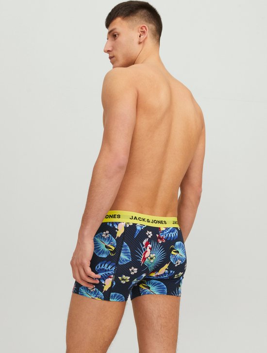 Man (achterkant) met donkerblauwe boxershorts met tropische print van papegaaien en bladeren. Gele JACK & JONES tailleband.