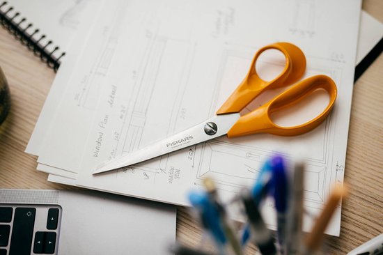 Oranje Fiskars schaar rust op bouwplannen.