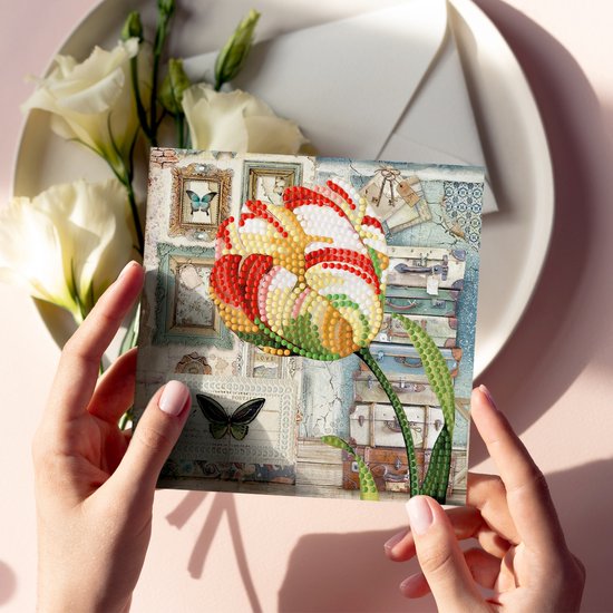 Wenskaart met diamantschilderij van een grote tulp in rood, wit en geel, met koffers en vlinder.