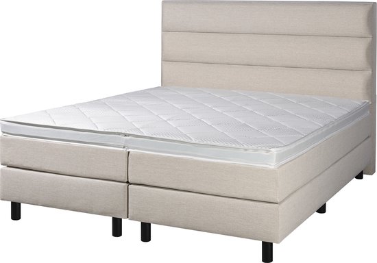 Boxspring met beige gestoffeerde basis, gestreept hoofdbord en een witte matrastop.