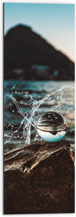 Dibond - Glazen Bol op een Rots langs het Water - 30x90 cm Foto op Aluminium (Wanddecoratie van metaal)