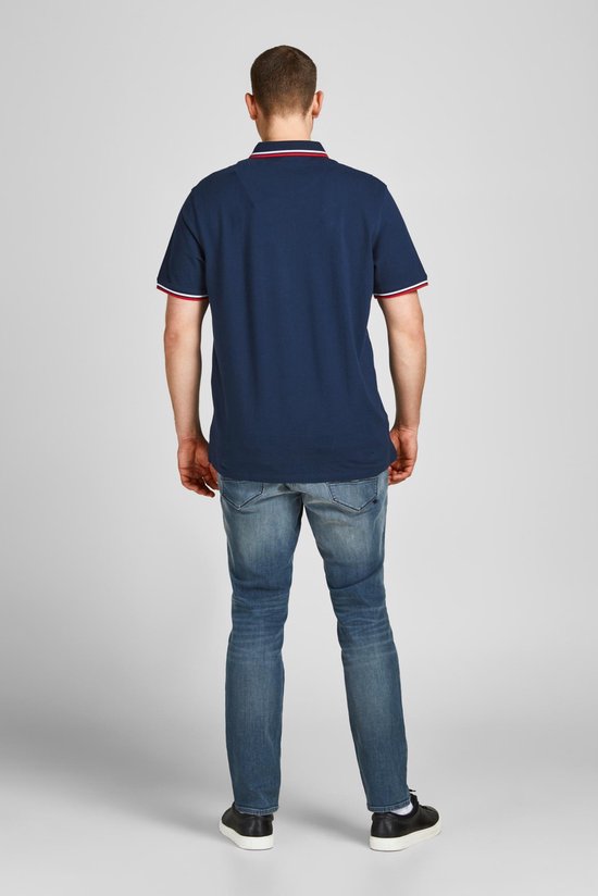 Achterkant van een man die een donkerblauwe polo met gestreepte kraag en mouwen draagt.