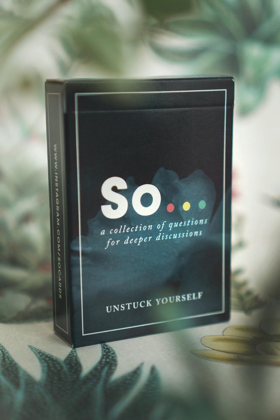 Donkerblauwe doos van 'So... a collection of questions for deeper discussions', met de tekst 'Unstuck Yourself'. Achtergrond met planten.