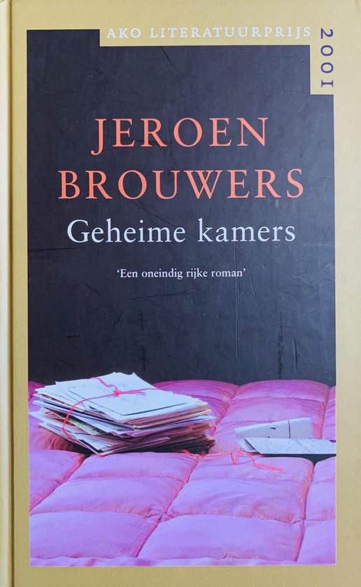 Boek "Geheime kamers" van Jeroen Brouwers, met op de voorgrond een stapel papieren op een roze doorgestikte deken.