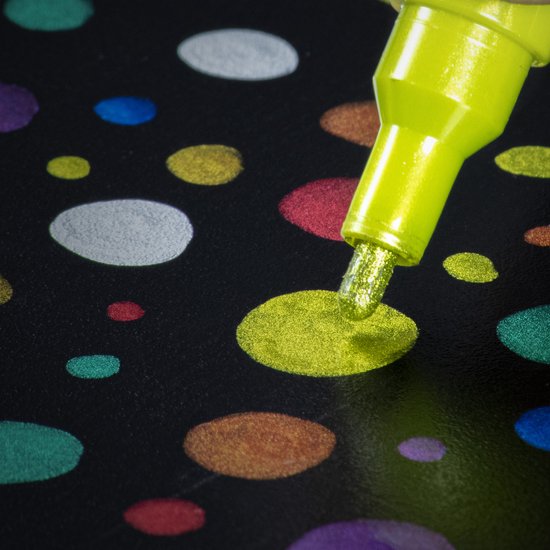 Lichtgroene metallic stift tekent een gele cirkel met glitter op een zwart oppervlak met gekleurde cirkels.