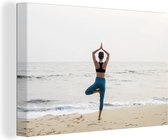 Une femme sur la plage faisant du yoga sur toile 140x90 cm - Tirage photo sur toile (Décoration murale salon / chambre)