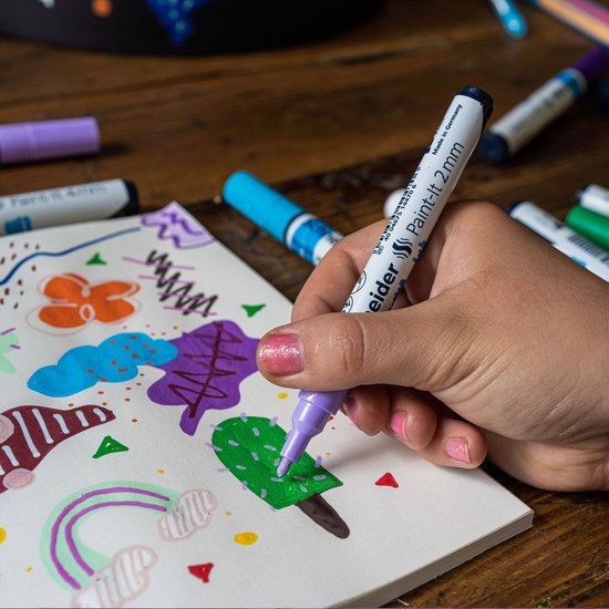 Hand die met lila stift tekent op papier, met afbeeldingen van bloemen en planten.