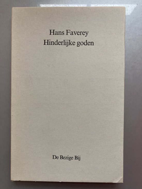 Boek "Hinderlijke goden" van Hans Faverey, uitgegeven door De Bezige Bij. Off-white kaft met verticale ribbels.