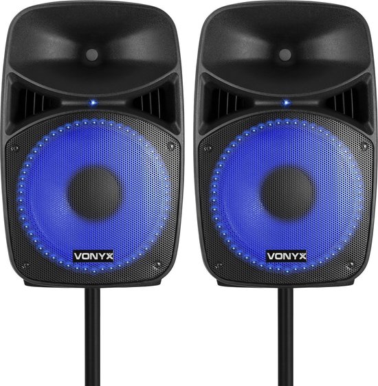 Twee zwarte Vonyx PA-luidsprekers met gloeiende blauwe ringen rond de luidsprekers, op zwarte stands.