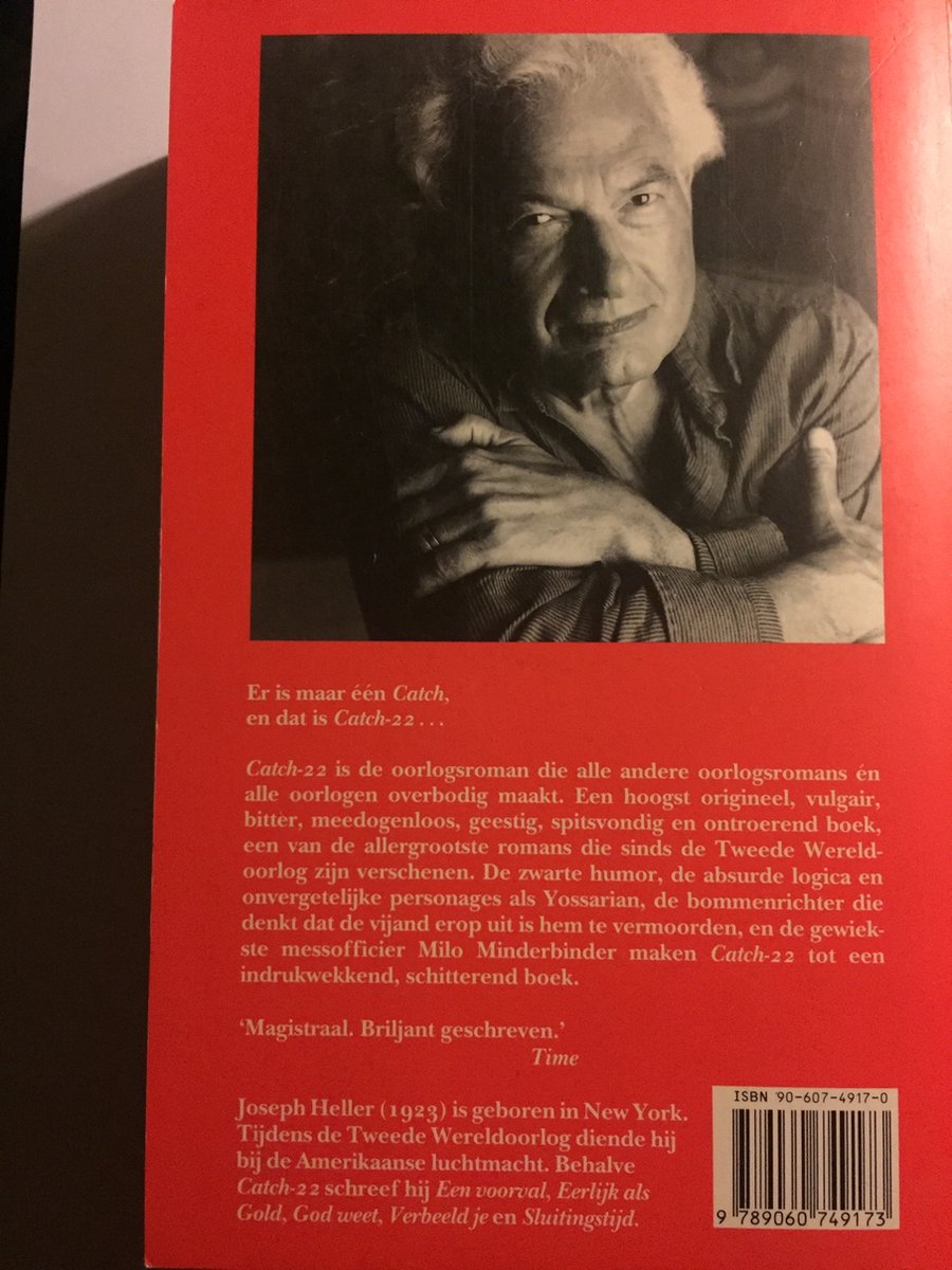 De achterkant van het boek toont een zwart-witfoto van Joseph Heller met een glimlach. Tekst is in het rood.