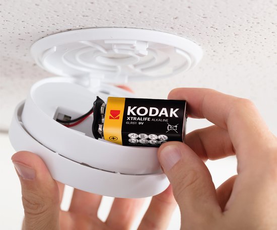 Hand plaatst Kodak Xtralife alkaline 9V batterij in rookmelder.