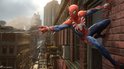 Spider-Man in rood en blauw pak, zwaaiend met webben, op een muur van een gebouw met uitzicht op de stad.