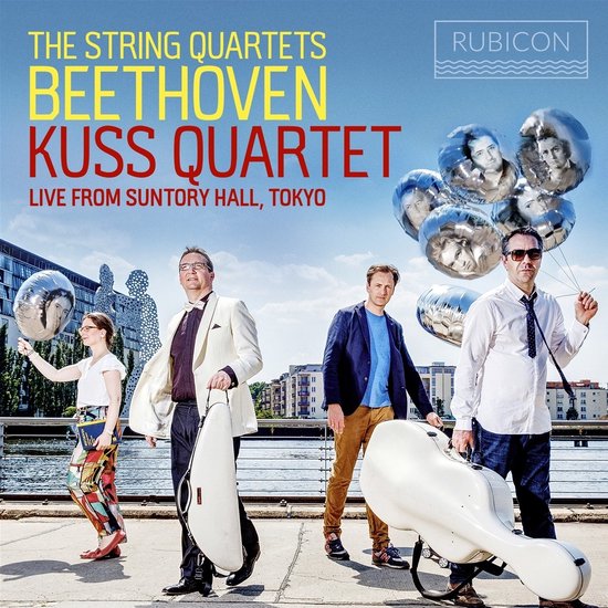 Vier muzikanten van Kuss Quartet staan buiten met zilveren ballonnen. Kuss Quartet - Beethoven: The String Quartets Live from Suntory Hall, Tokyo.