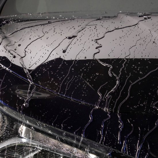 Voiture sombre avec une couche brillante et réfléchissante ornée de gouttelettes d'eau et de lignes fluides.