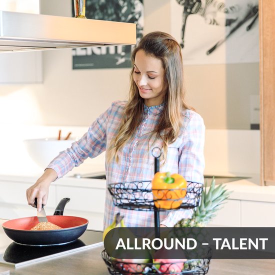 Een vrouw met een geruit overhemd bakt in een keuken. Ze gebruikt een spatel in een koekenpan. "Allround - talent".