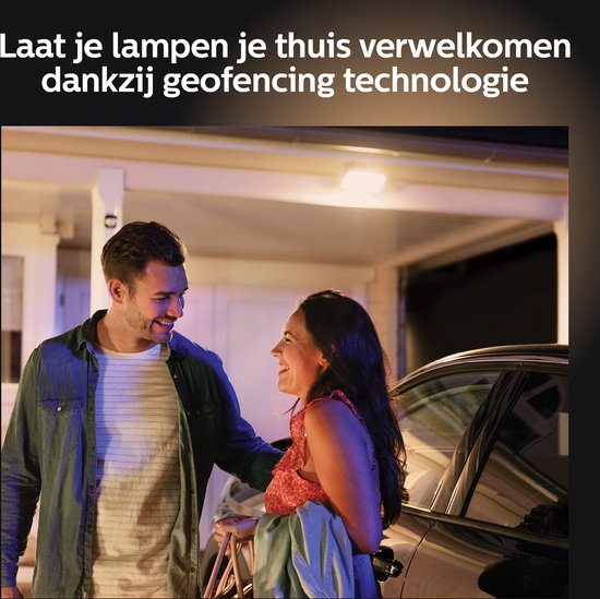 Een koppel lacht bij een auto bij een huis. Lampen welkom thuis met geofencing.