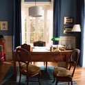 Une lampe de bureau verte est posée sur un bureau en bois dans un bureau.