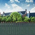Groen schaduwdoek met opgestapelde stenen hekwerk en grote bomen op de achtergrond.