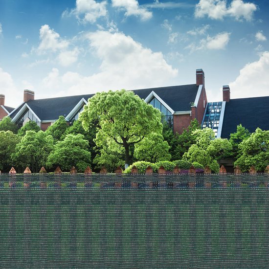 Groen schaduwdoek met opgestapelde stenen hekwerk en grote bomen op de achtergrond.