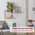 Woonkamerinterieur met drie wandrekken, versierd met een plant, diffuser en kaarsen.
