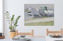 Peinture de linge séchant dans des couleurs claires et douces près de l'eau. L'œuvre est accrochée au-dessus d'une table à manger avec des chaises en bois.