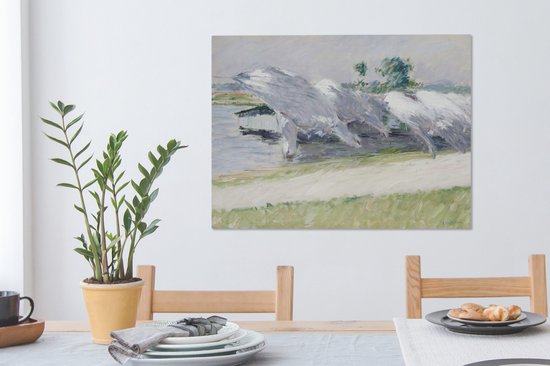 Peinture de linge séchant dans des couleurs claires et douces près de l'eau. L'œuvre est accrochée au-dessus d'une table à manger avec des chaises en bois.