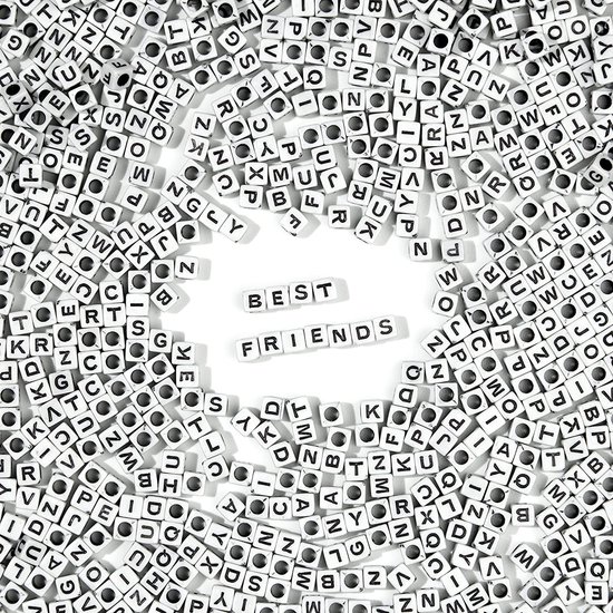 Veel witte letterkralen met zwarte letters verspreid, met 'BEST' en 'FRIENDS' in het midden.