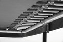 Onderkant van een trampoline, close-up van de zilverkleurige veren die aan het frame zijn bevestigd.