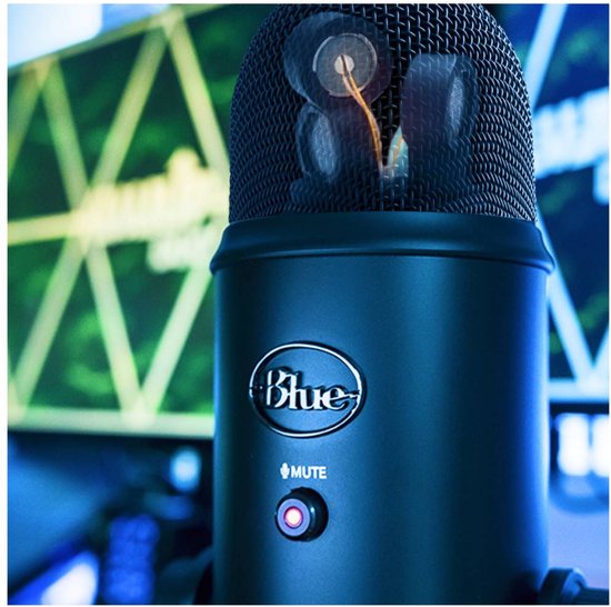 Gros plan sur le dessus d'un microphone Yeti noir avec le voyant rouge de sourdine allumé.