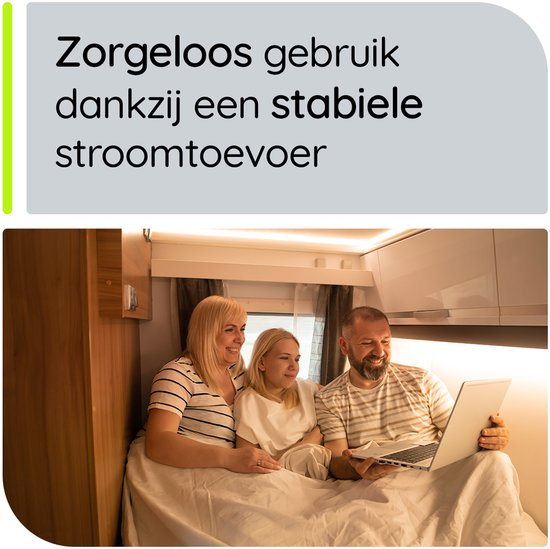Gelukkige familie van drie personen die op een bed in een camper naar een laptop kijken.