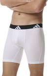 Wit boxerhort met zwarte band met witte Adidas logo's, gedragen door een model.