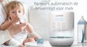Luvion Smartlift Pro flessenwarmer met digitale display, naast een baby die een fles krijgt.
