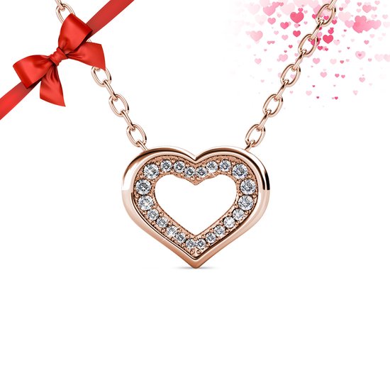 Gouden hartvormige ketting met fonkelende kristallen, een rode strik en roze hartjes op de achtergrond.