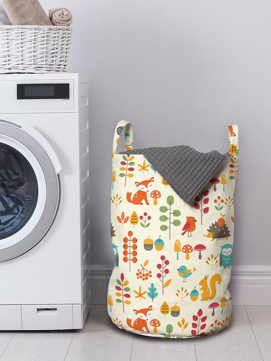 Wasmand met herfst bosdieren patroon: vossen, uilen, eekhoorns, vogels, paddenstoelen en bessen, naast een wasmachine.