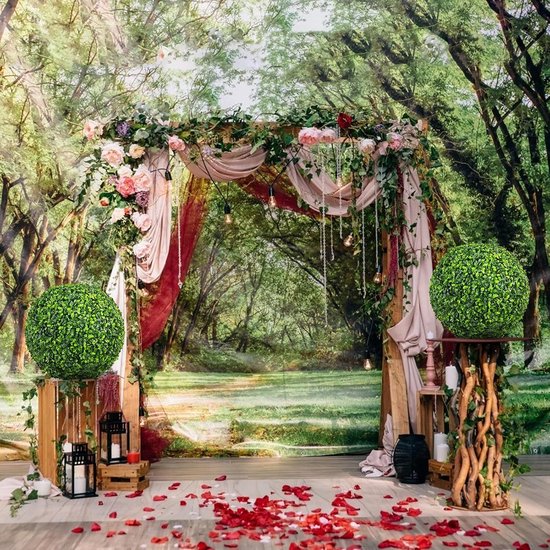 Decoratieve bruiloftsbrug versierd met bloemen, draperieën, lampjes en twee buxusbollen op houten standaarden.